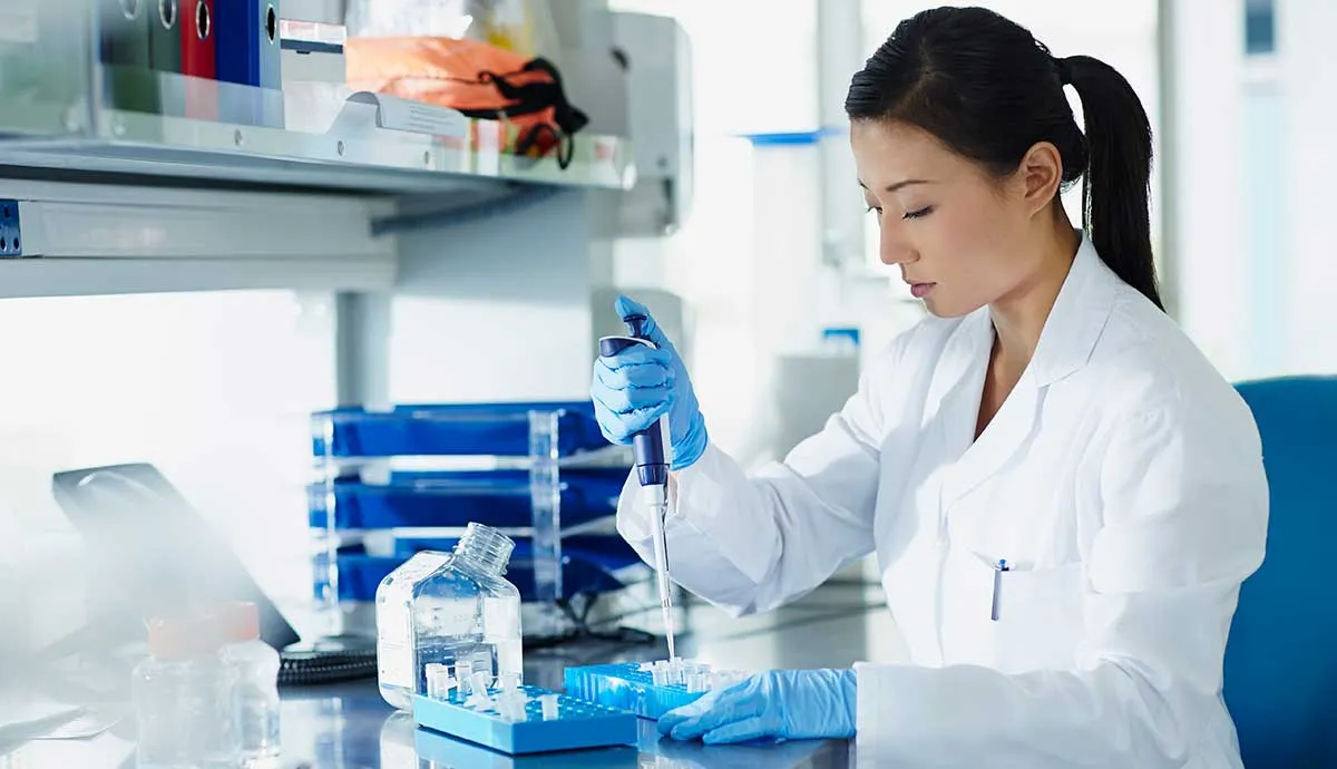 Scientist pipetting samples into eppendorf tubes in research laboratory
