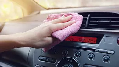 person dusting interior of car